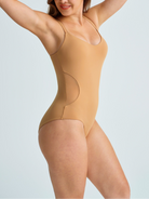 Woman wearing a nude plus size full bodysuit. The brand is Baerely who supports brabic bodysuit shapewear & luxury-vita shapewear bodysuit & Women’s tummy control butt-lifting shapewear.